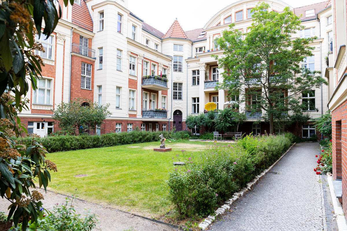 Ankommen im grünen Innenhof: Zugang zur Physiotherapie-Praxis Lucas Appel in Potsdam