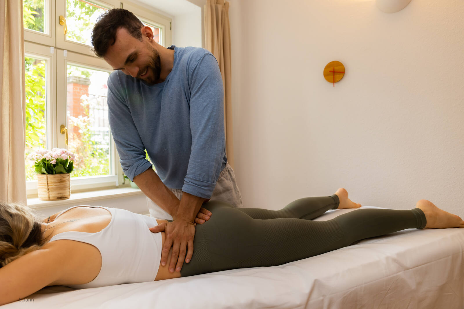 Lucas Appel behandelt eine Patientin auf der Behandlungsliege in seiner Physiotherapie-Praxis in Potsdam